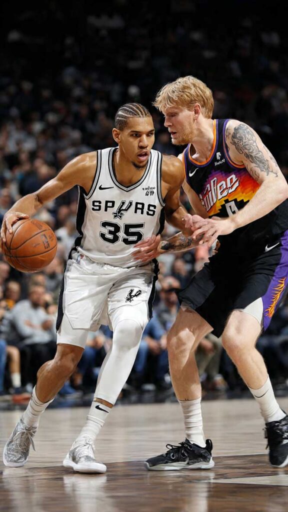 Basketball player in a white Spurs uniform dribbling the ball while being guarded by an opponent in a black and orange jersey.